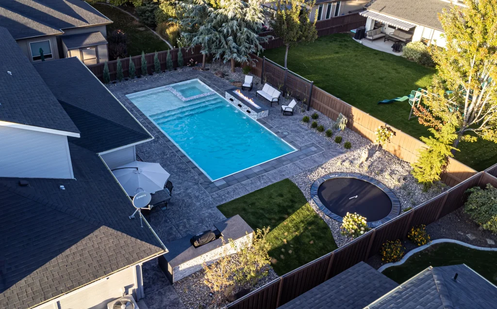 Aerial view of a backyard pool, spa and stamped concrete terrace