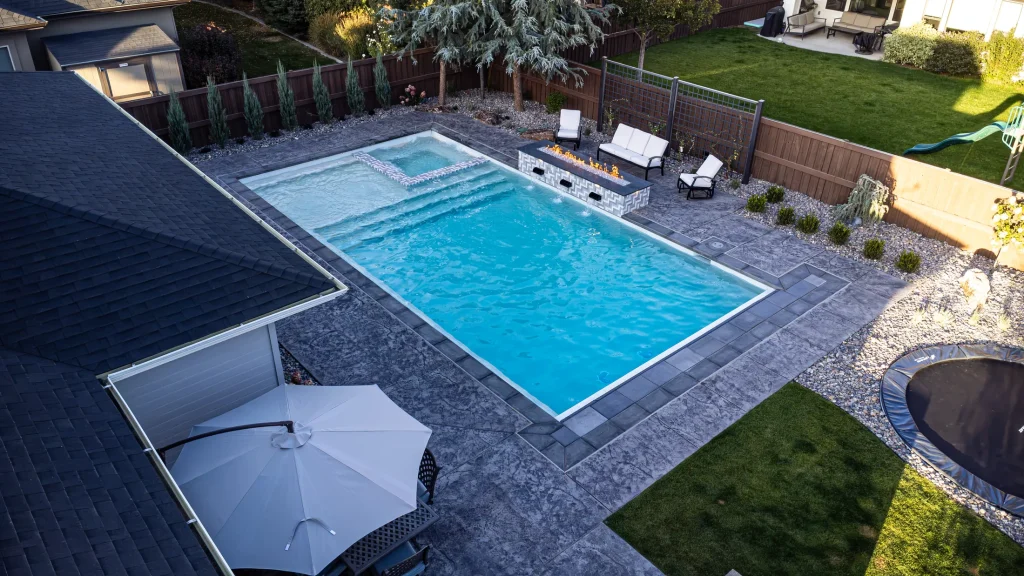Aerial view of a backyard pool, spa and stamped concrete terrace