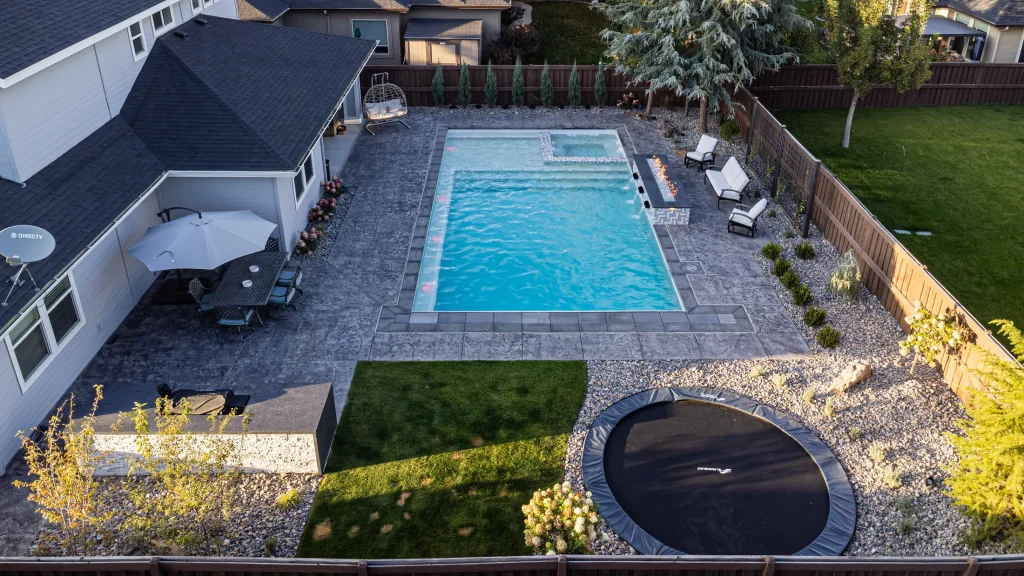 Aerial view of a backyard pool, spa and stamped concrete terrace
