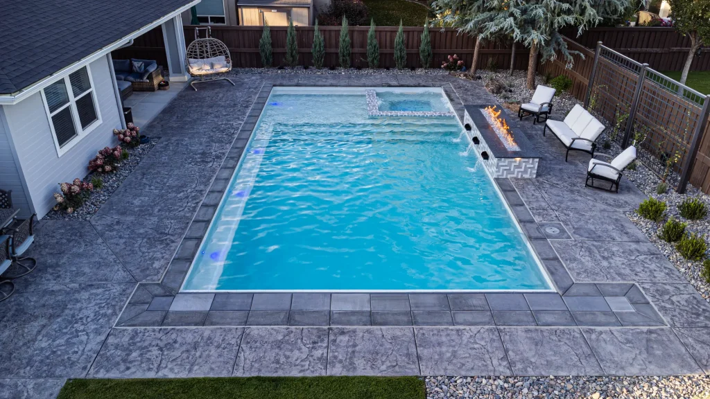 Aerial view of a backyard pool, spa and stamped concrete terrace