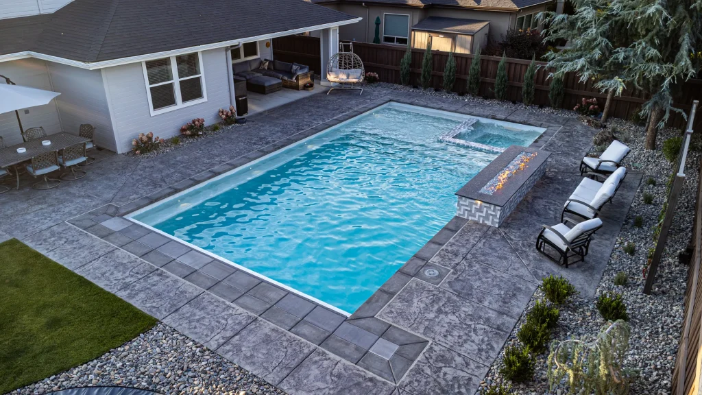 Aerial view of a backyard pool, spa and stamped concrete terrace