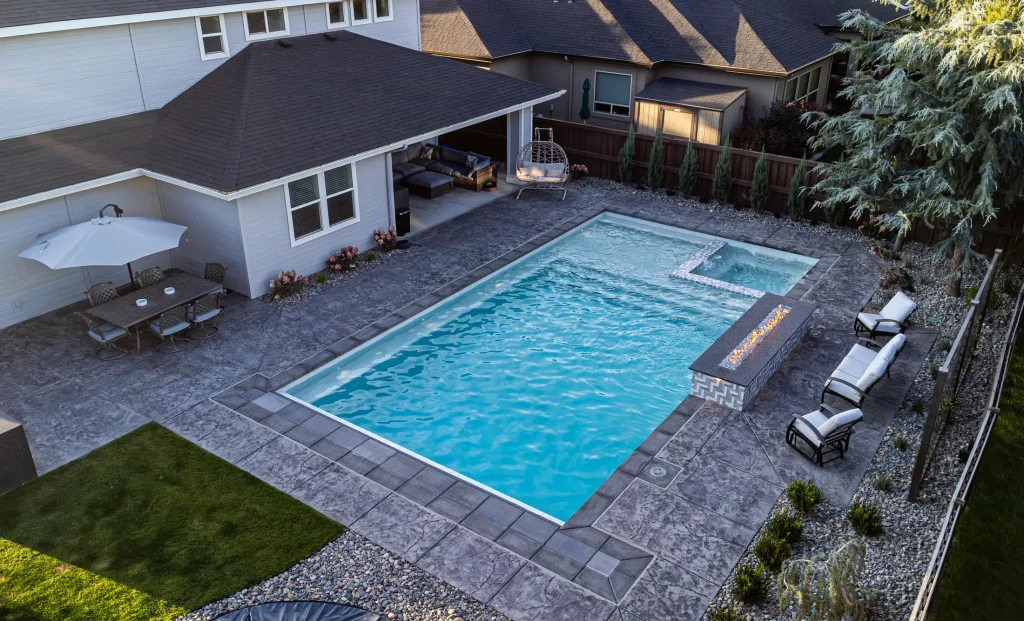 Aerial view of a backyard pool, spa and stamped concrete terrace