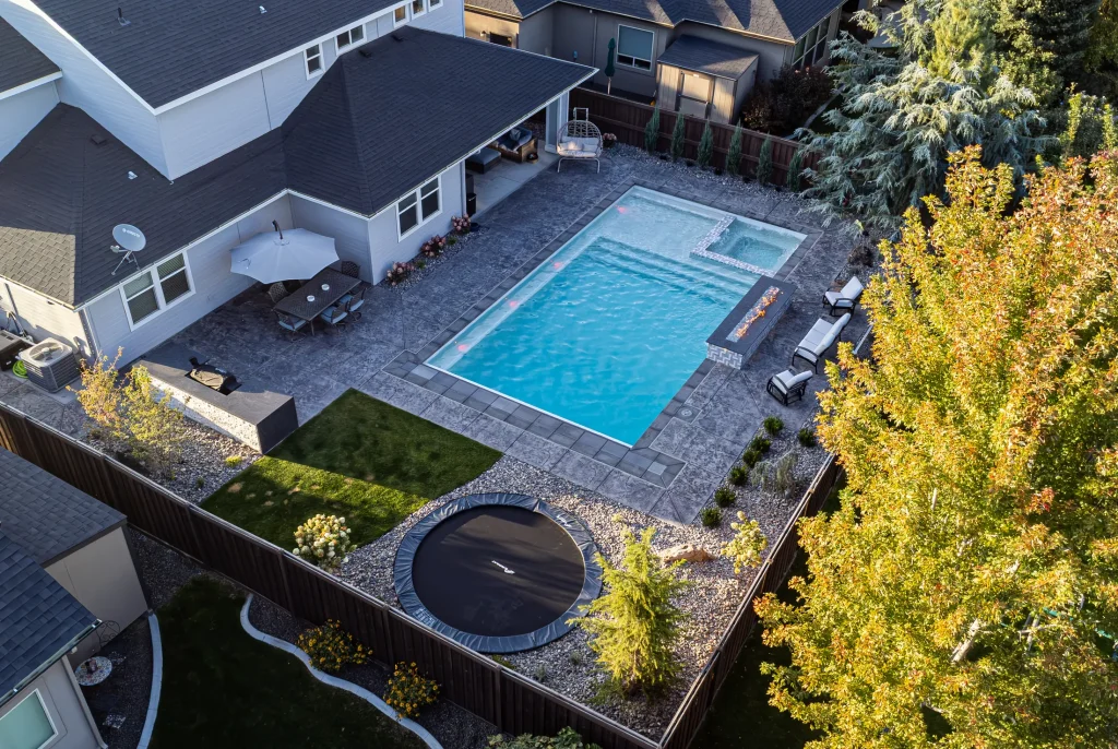 Aerial view of a backyard pool, spa and stamped concrete terrace