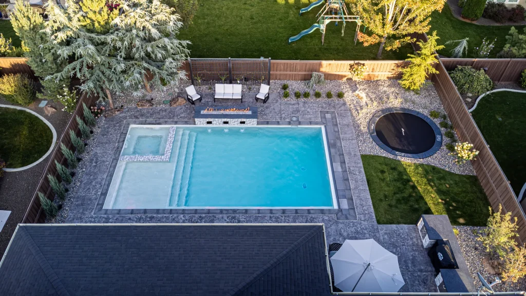 Aerial view of a backyard pool, spa and stamped concrete terrace