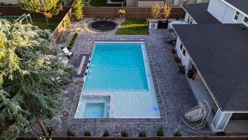 Aerial view of a backyard pool, spa and stamped concrete terrace