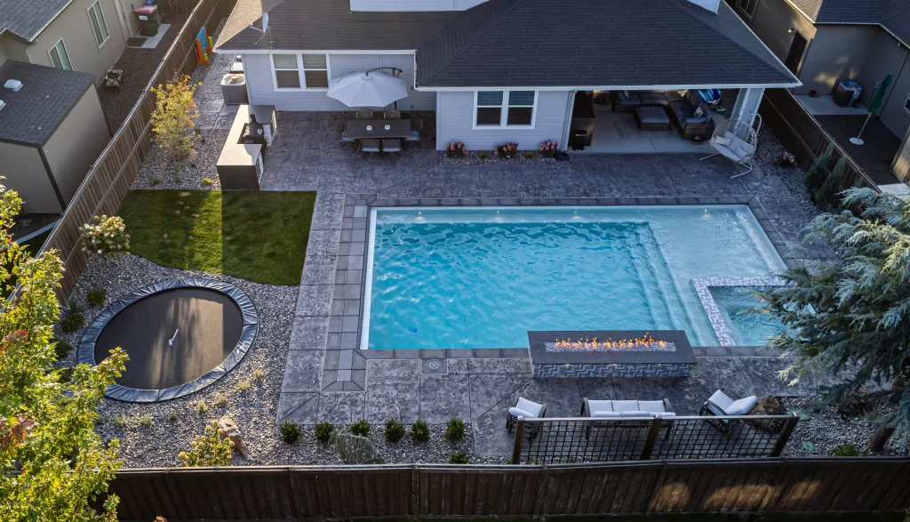 Aerial view of a backyard pool, spa and stamped concrete terrace