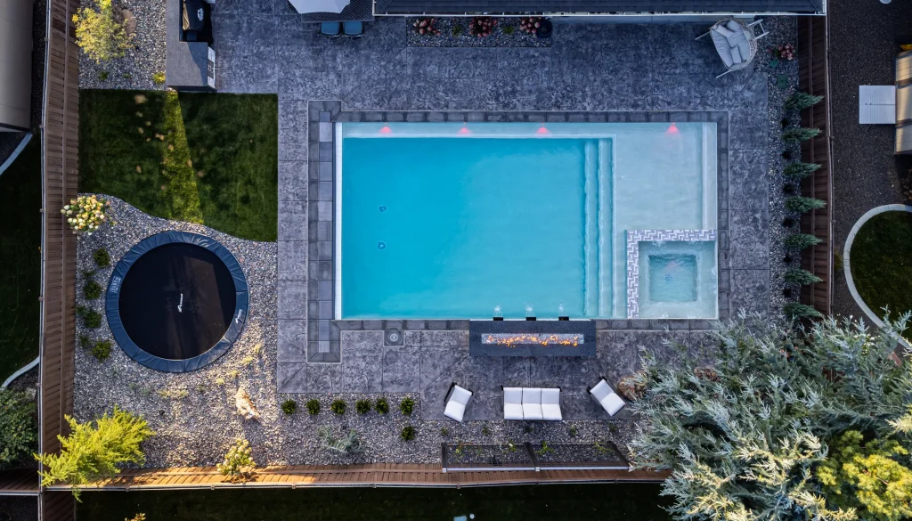 Aerial view of a backyard pool, spa and stamped concrete terrace