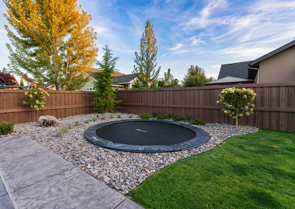 Sunken trampoline set into a landscaped lawn
