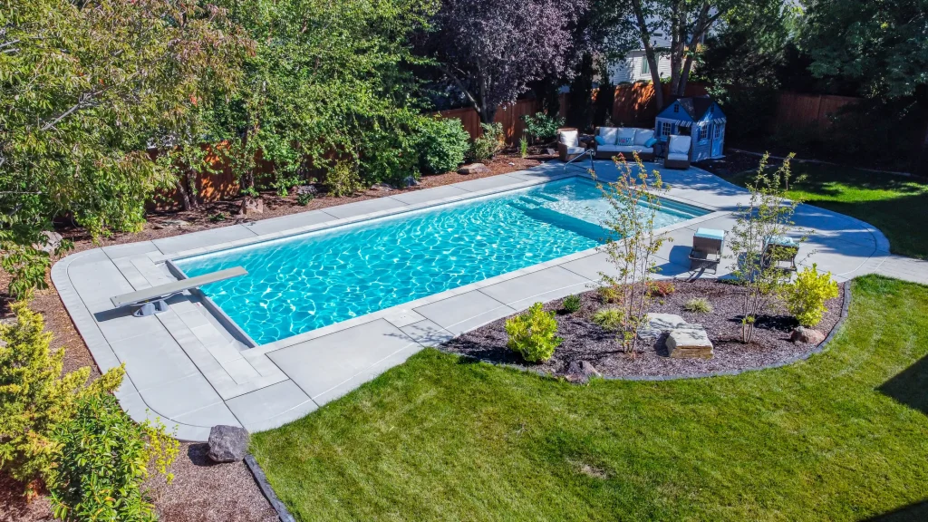 Aerial view of a pool with a curved concrete deck and planting