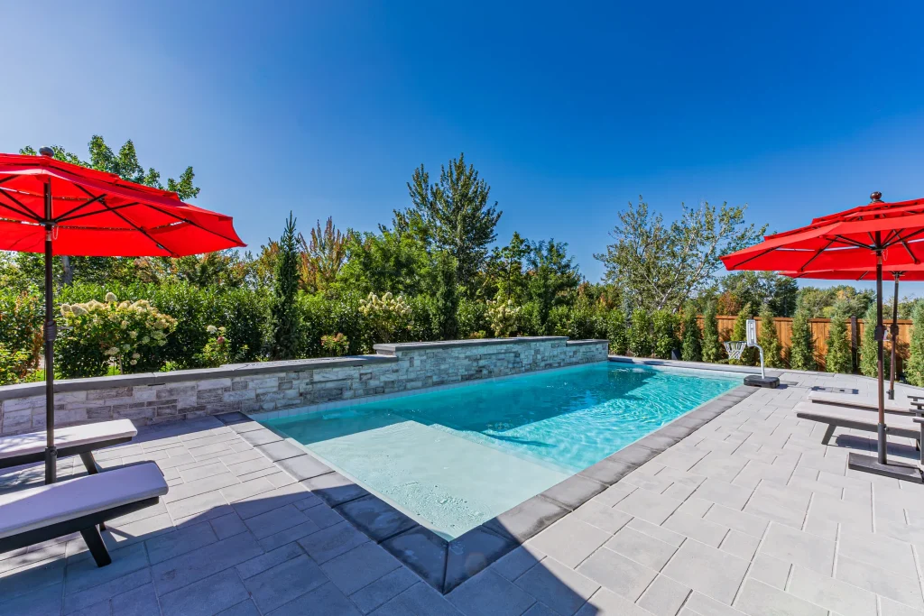 Pool with stone feature wall and sun deck