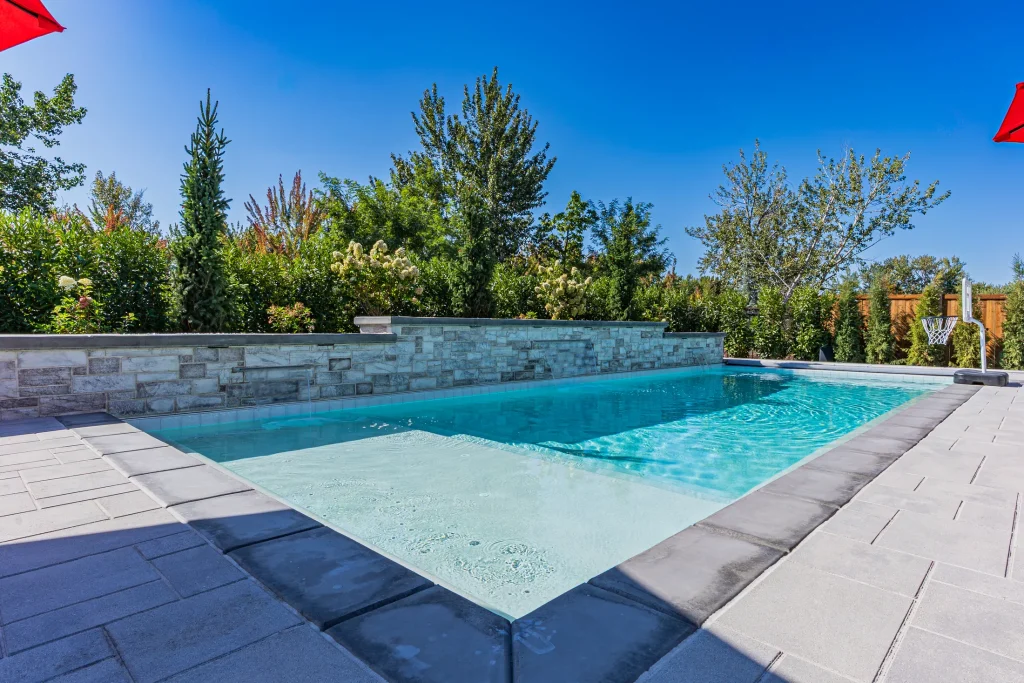 Pool with stone feature wall and sun deck