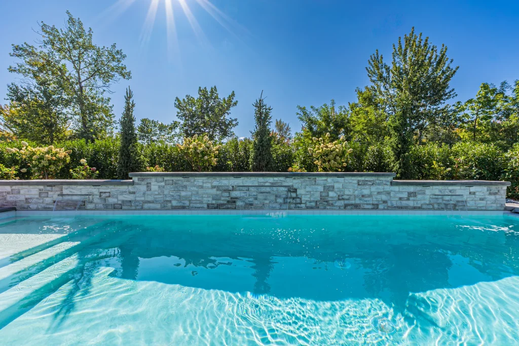 Pool with stone feature wall and sun deck